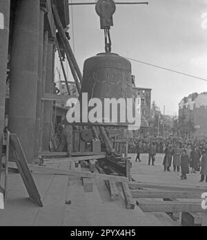 Foto della Campana della libertà su Rathausplatz come viene eretta da una gru da un telaio di legno poco prima della sua installazione nella torre della sede del sindaco di Berlino Ernst Reuter (1948-1953) il 21 ottobre 1950. A sinistra, una delle colonne della porta principale e del ponteggio della torre. Sullo sfondo, soldati degli Stati Uniti Esercito, passanti e giornalisti. Dietro, le case parzialmente distrutte a Badenschen-Strasse e Martin-Luther-Strasse. La campana suonò per la prima volta durante la cerimonia del 24 ottobre, in occasione della Giornata delle Nazioni Unite (ONU). Foto Stock