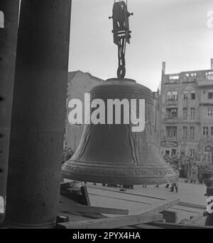 Foto della Campana della libertà su un telaio di legno appena prima della sua installazione nella torre della sede del sindaco di Berlino Ernst Reuter (1948-1953) il 21 ottobre 1950. La campana suonò per la prima volta durante la cerimonia del 24 ottobre, in occasione della Giornata delle Nazioni Unite (ONU). La campana viene sollevata di fronte alle colonne della porta principale. Sullo sfondo, gli spettatori di fronte ad alcune case distrutte da bombardamenti. Foto Stock