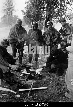 A est di Gshatsk (a nord-est di Smolensk) nella sezione centrale del fronte orientale, alcuni fanti si sono riuniti intorno ad un fuoco per riscaldarsi e preparare il cibo. Foto: Böhmer [traduzione automatica] Foto Stock