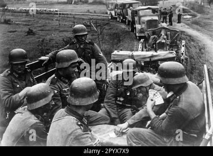I soldati di un'unità di artiglieria tedesca giocano a carte durante una pausa nella marcia. Dietro il mockup un campo howitzer 10,5cm. Foto: Schröter [traduzione automatica] Foto Stock