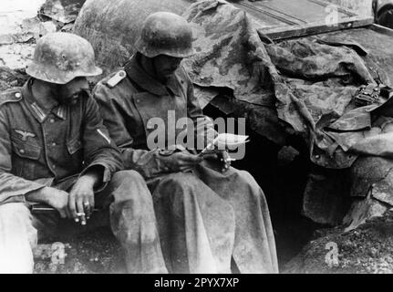 Soldati che leggono il giornale vicino a Koporje nella sezione settentrionale del fronte orientale. Foto: Schürer. [traduzione automatica] Foto Stock