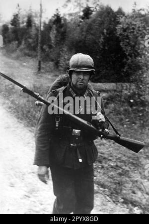 Un uomo di fanteria sulla marcia sul fronte orientale. Intorno al collo porta il suo Karabiner 98 con braccio laterale montato. Foto: Lessmann [traduzione automatica] Foto Stock