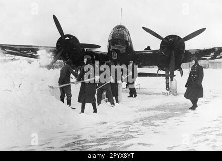 Junkers Ju 88 aerei da combattimento che vengono spalati liberamente da uomini di equipaggio di terra in un campo aereo nel nord della Francia. Foto: Boettcher. [traduzione automatica] Foto Stock