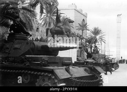 Tedesco Panzerkampfwagen III di fronte al monumento Mussolini a Tripoli (Libia moderna). Sullo sfondo c'è un serbatoio italiano M13/40 della divisione blindata Ariete. Foto: Borchert [traduzione automatica] Foto Stock