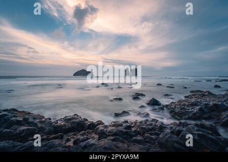 Stagcapes al tramonto, con rocce sulla superficie del mare. Spiaggia di Mosteiros sull'isola di Sao Miguel, Azzorre, Portogallo Foto Stock