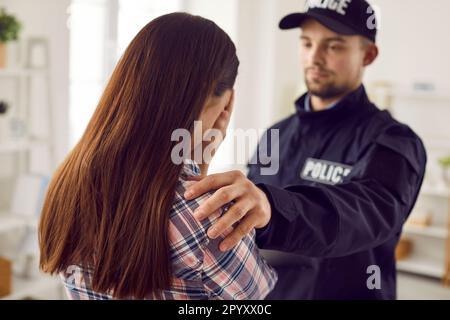 Poliziotto in uniforme allietando la vittima di furto di casa Foto Stock