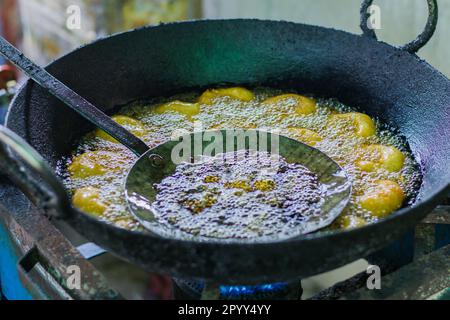 Mendu wada o medu vada fritti in un kadhai i al ristorante sulla strada. Il Meduwada è un popolare spuntino dell'India del Sud servito con sambar e chutney Foto Stock