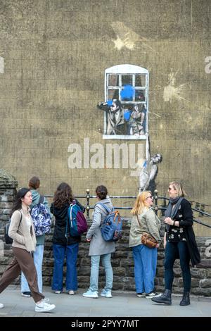 I visitatori possono ammirare il "Well-Hung Lover" di Banksy, che è stato girato con una pistola da paintball su Frogmore Street (vista da Park Street) Bristol. Foto Stock