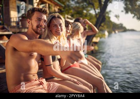 Giovane coppia seduta sul molo e godendosi insieme Foto Stock