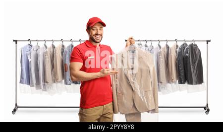 Lavoratore maschio che mostra un vestito a lavasciuga davanti a scaffali con appesi vestiti isolati su uno sfondo bianco Foto Stock