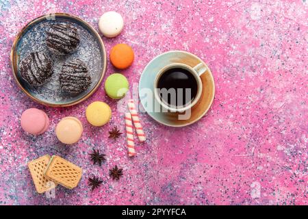 vista dall'alto torte al cioccolato con macaron francesi sullo sfondo rosa biscotto dolce torta di zucchero biscotti torta Foto Stock