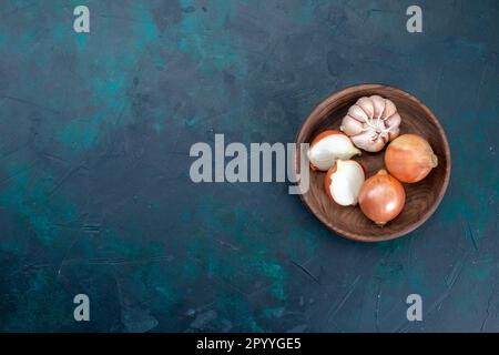 vista dall'alto cipolle con aglio su sfondo blu scuro cibo verdura Foto Stock