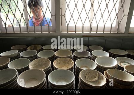 Un archeologo marittimo è fotografato con antiche ciotole di ceramica cinesi recuperate dal naufragio di Cirebon del IX-X secolo trovato nel 2003 nel Mare di Giava a nord di Cirebon, Giava Occidentale, Indonesia. Fotografato presso il magazzino della direzione di Archeologia subacquea, Ministero della Cultura e del Turismo indonesiano a Giacarta, Indonesia. Foto Stock