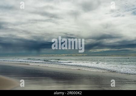 Nuvole di pioggia che pendono in basso sul mare in una giornata autunnale a Currumbin Beach, Queensland, Australia. Foto Stock