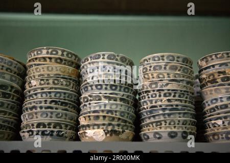 Antiche ciotole cinesi in ceramica conosciute come 'Yue ware' senza acqua dal relitto di Cirebon del 9th-10th secolo trovato nel 2003 nel Mare di Giava a nord di Cirebon, Giava Occidentale, Indonesia. Fotografato presso il deposito della direzione di Archeologia subacquea, Ministero indonesiano della Cultura e del Turismo a Giacarta, Indonesia. Foto Stock