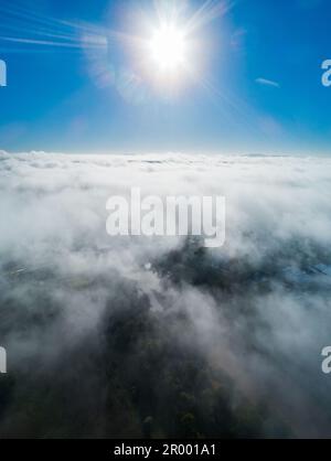 Alba argentata con raggi di luce su paesaggi di nebbia e nebbia Foto Stock