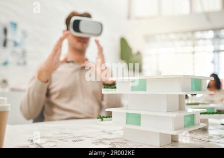 Designer che utilizza il visore VR per pianificare il suo edificio.architetto che gioca con gli occhiali per realtà virtuale. Progettista che utilizza un simulatore di architettura ai. Uomo d'affari Foto Stock