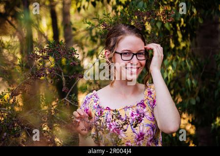 Ragazza con gli occhiali nel Bush australiano che sorride alla fotocamera Foto Stock