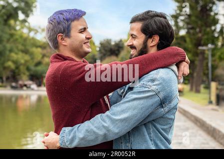 Gay coppia maschio abbracciarsi e guardarsi l'un l'altro Foto Stock