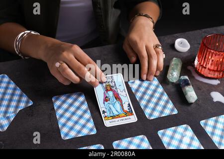 Fortune Teller che prevede il futuro sulla diffusione di carte tarocchi al tavolo grigio, primo piano Foto Stock