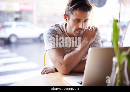 Computer portatile, pensiero e uomo freelancer che lavorano in un ristorante come lavoro remoto in un bar o caffetteria e leggere un'e-mail. Internet, sito web o serio Foto Stock