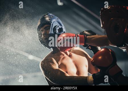 Boxer utilizzare varie combinazioni di punzone, tra cui la scopata, gancio, taglio superiore, croce, rotazione, dritta. Avvicinandosi per fare l'avversario su corde e knocko Foto Stock