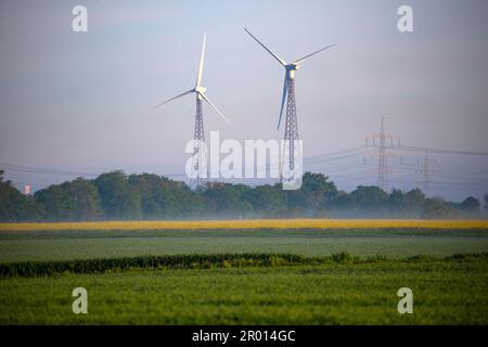 Bornheim, Germania. 06th maggio, 2023. Dietro un fiorente campo di colza vicino a Bornheim, all'orizzonte si possono vedere turbine eoliche. Credit: Thomas Banneyer/dpa/Alamy Live News Foto Stock