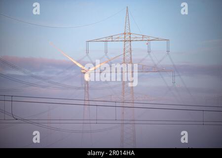 Bornheim, Germania. 06th maggio, 2023. Un polo di potenza e una turbina eolica si trovano nella luce del mattino in un campo vicino a Bornheim, nella Renania. Credit: Thomas Banneyer/dpa/Alamy Live News Foto Stock