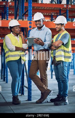 Software che protegge il sito di costruzione. un gruppo di costruttori che utilizzano un tablet digitale mentre lavorano in cantiere. Foto Stock