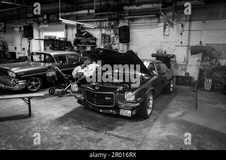 Un vecchio cheverolet con cofano motore aperto si trova in un'officina Foto Stock