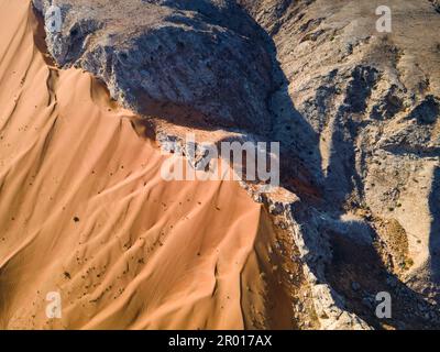 Scenic Fossil Rock nel deserto di Sharjah degli Emirati Arabi Uniti vista aerea. Sabbia che incontra la montagna rocciosa nel deserto degli Emirati Arabi Uniti Foto Stock