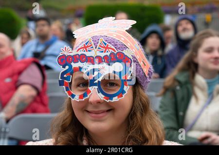 Edimburgo, Scozia, Regno Unito. 6 maggio 2023. Scene da Edimburgo il giorno dell'incoronazione di re Carlo III Membro del pubblico che indossa una corona di cartone e occhiali da incoronazione nei giardini di West Princes Street. Iain Masterton/Alamy Live News Foto Stock