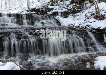 Piccola cascata Vasaristi in inverno, parco nazionale di Lahemaa, Estonia. Esposizione lunga Foto Stock