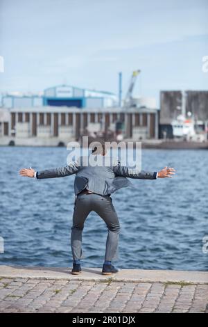 La tentazione di abbandonare è più forte prima di riuscire. Scatto a tutta lunghezza di un uomo d'affari irriconoscibile in piedi sul molo e che vuole saltare Foto Stock