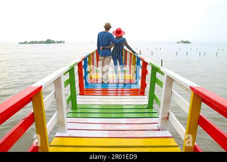 Coppia di relax insieme sul lungomare colorato legno Boardwalk Foto Stock