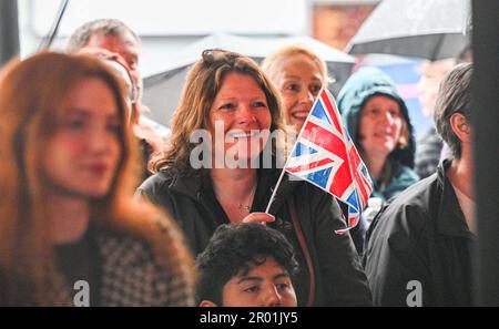 Brighton UK 6th maggio 2023 - le folle guardano l'incoronazione di Re Carlo III a un grande schermo in Brighton's Jubilee Square oggi : Credit Simon Dack / Alamy Live News Foto Stock