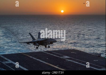 USS Nimitz, acque internazionali. 03 maggio, 2023. NEGLI STATI UNITI Navy F/A-18E Super Hornet Fighter Aircraft dai Blue Diamonds di Strike Fighter Squadron 146, si avvicina per un atterraggio arrestato sul ponte di volo della portaerei di classe Nimitz USS Nimitz in corso al tramonto che conduce operazioni di routine, il 3 maggio 2023 nel Mar Cinese Meridionale. Credit: MC2 David Rowe/US Navy Photo/Alamy Live News Foto Stock