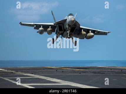 USS Nimitz, acque internazionali. 21 aprile 2023. NEGLI STATI UNITI Navy F/A-18E Super Hornet Fighter Aircraft from the Kestrels of Strike Fighter Squadron 137, si avvicina per un atterraggio arrestato sul ponte di volo della portaerei di classe Nimitz USS Nimitz in corso di operazioni di routine, il 21 aprile 2023 nel Mar Cinese Meridionale. Credit: MC2 Justin McTaggart/US Navy Photo/Alamy Live News Foto Stock