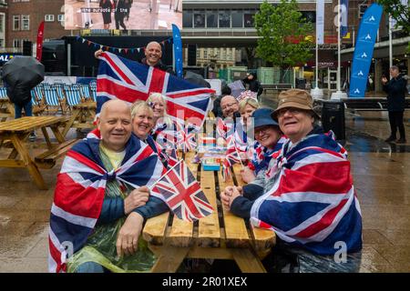 Coventry, West Midlands, Regno Unito. 6th maggio, 2023. La gente di tutto il paese è uscita per celebrare oggi l'incoronazione di re Carlo III. Un gruppo di Coventry Scouts si riunisce sotto la pioggia per guardare l'incoronazione sul grande schermo di Broadgate, Coventry City Centre. Credit: AG News/Alamy Live News Foto Stock