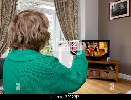 Warrington, Cheshire, Regno Unito. 6th maggio, 2023. REGNO UNITO. La gente di tutto il paese ha guardato l'incoronazione di re Carlo III in televisione. Una donna tiene in mano una tazza Union Flag per onorare il Re al Coronation Credit: John Hopkins/Alamy Live News Foto Stock