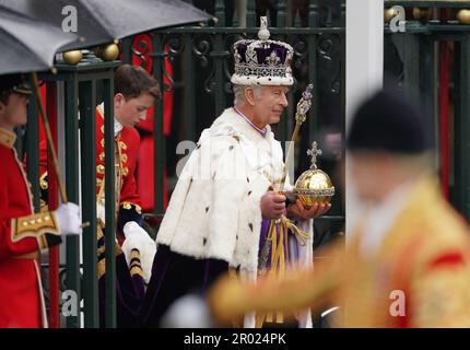 Re Carlo III, indossando la Corona di Stato Imperiale, lascia l'Abbazia di Westminster nel centro di Londra dopo la cerimonia di incoronazione. Data immagine: Sabato 6 maggio 2023. Foto Stock