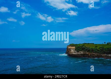 Pantai Klayar o Klayar Beach con rocce e onde forti contro il cielo blu. Sfocatura del movimento. Fotografia di paesaggi. Foto Stock