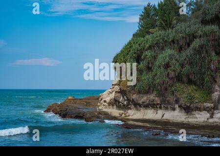 Pantai Klayar o Klayar Beach con rocce e onde forti contro il cielo blu. Sfocatura del movimento. Fotografia di paesaggi. Foto Stock