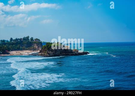 Pantai Klayar o Klayar Beach con rocce e onde forti contro il cielo blu. Sfocatura del movimento. Fotografia di paesaggi. Foto Stock