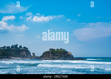 Pantai Klayar o Klayar Beach con rocce e onde forti contro il cielo blu. Sfocatura del movimento. Fotografia di paesaggi. Foto Stock