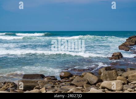 Pantai Klayar o Klayar Beach con rocce e onde forti contro il cielo blu. Sfocatura del movimento. Fotografia di paesaggi. Foto Stock