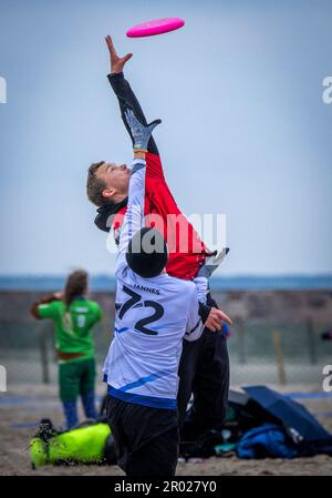 Rostock, Germania. 06th maggio, 2023. Al quinto Campionato tedesco Mixed Beach in beach frisbee, le squadre di Rotpot Braunschweig (bianco) e Funatics Hannover giocano l'una contro l'altra sulla spiaggia del Mar Baltico di Warnemünde. Nel concorso, cinque giocatori per squadra cercano di ottenere il frisbee nella zona finale della metà dell'avversario. Un totale di 24 squadre con 200 giocatori provenienti da tutta la Germania giocano per il campionato tedesco. Credit: Jens Büttner/dpa/Alamy Live News Foto Stock