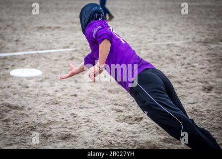 Rostock, Germania. 06th maggio, 2023. Un giocatore della Goldfingers Potsdam cerca di prendere il disco sulla spiaggia del Mar Baltico a Warnemünde durante il quinto campionato tedesco di spiaggia mista in Beach Frisbee. Nel concorso, cinque giocatori per squadra cercano di ottenere il Frisbee nella zona finale della metà dell'avversario. Un totale di 24 squadre con 200 giocatori provenienti da tutta la Germania gareggiano per il campionato tedesco. Credit: Jens Büttner/dpa/Alamy Live News Foto Stock
