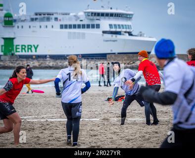 Rostock, Germania. 06th maggio, 2023. Al quinto Campionato tedesco Mixed Beach in beach frisbee, le squadre di Rotpot Braunschweig (bianco) e Funatics Hannover giocano l'una contro l'altra sulla spiaggia del Mar Baltico di Warnemünde. Nel concorso, cinque giocatori per squadra cercano di ottenere il frisbee nella zona finale della metà dell'avversario. Un totale di 24 squadre con 200 giocatori provenienti da tutta la Germania giocano per il campionato tedesco. Credit: Jens Büttner/dpa/Alamy Live News Foto Stock
