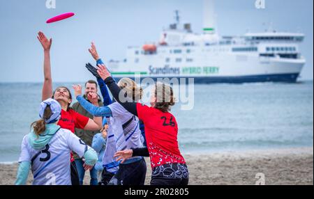 Rostock, Germania. 06th maggio, 2023. Al quinto Campionato tedesco Mixed Beach in beach frisbee, le squadre di Rotpot Braunschweig (bianco) e Funatics Hannover giocano l'una contro l'altra sulla spiaggia del Mar Baltico di Warnemünde. Nel concorso, cinque giocatori per squadra cercano di ottenere il frisbee nella zona finale della metà dell'avversario. Un totale di 24 squadre con 200 giocatori provenienti da tutta la Germania giocano per il campionato tedesco. Credit: Jens Büttner/dpa/Alamy Live News Foto Stock